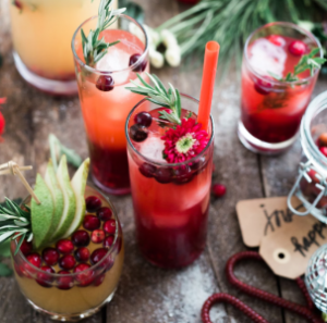 Colorful holiday cocktails with cranberries, pears, rosemary, and festive garnishes served at a Christmas pop-up bar near the NJ Shore.