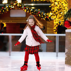 A young girl enjoying ice skating in a festive outdoor rink at the Jersey Shore, surrounded by holiday lights and decorations.